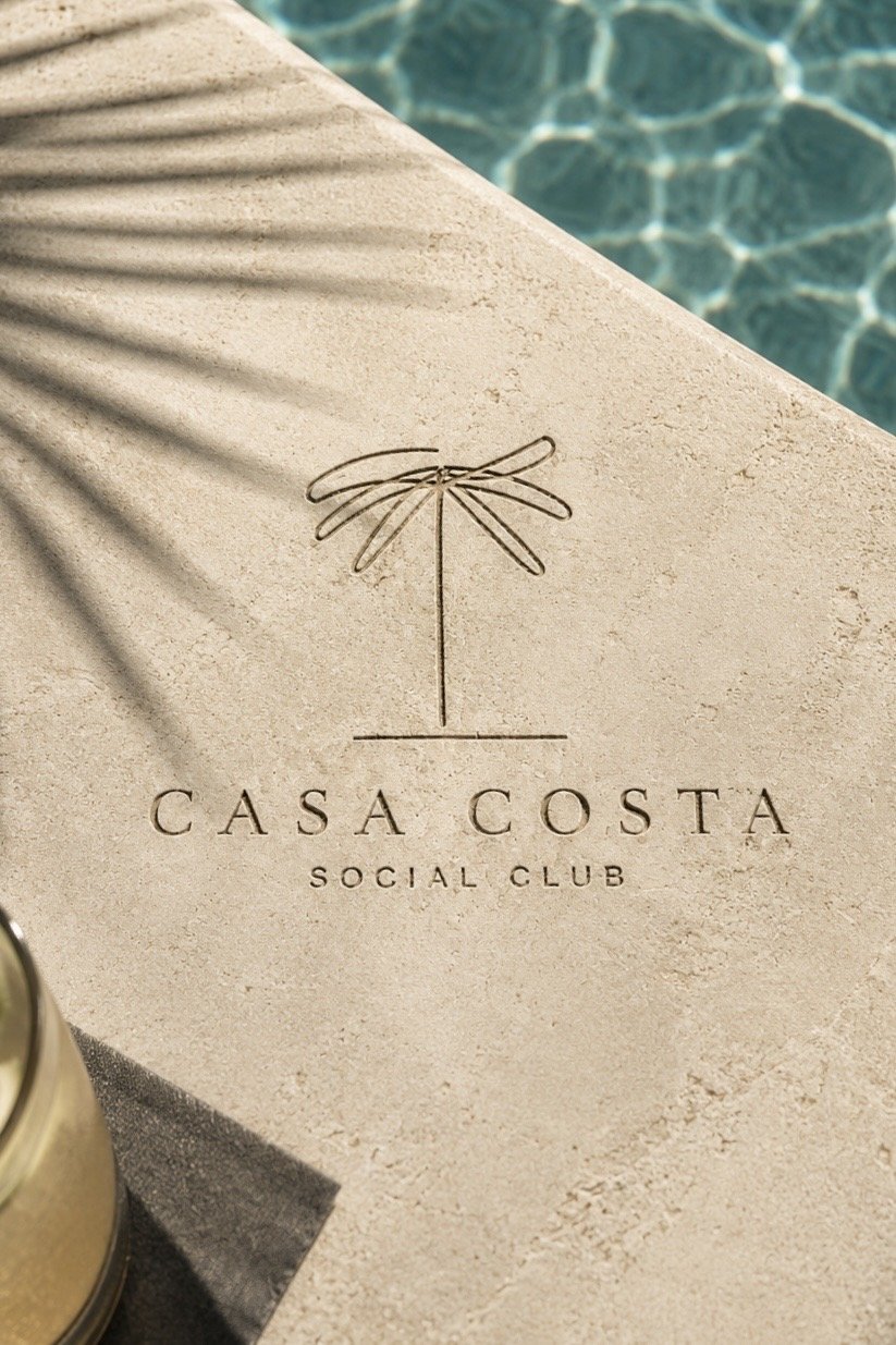 The Casa Costa mark engraved in stone beside the pool